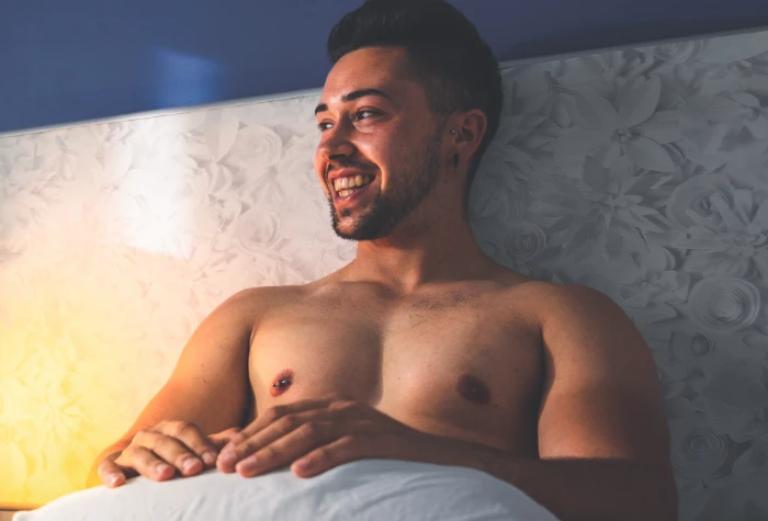 Gay man sitting on his bed